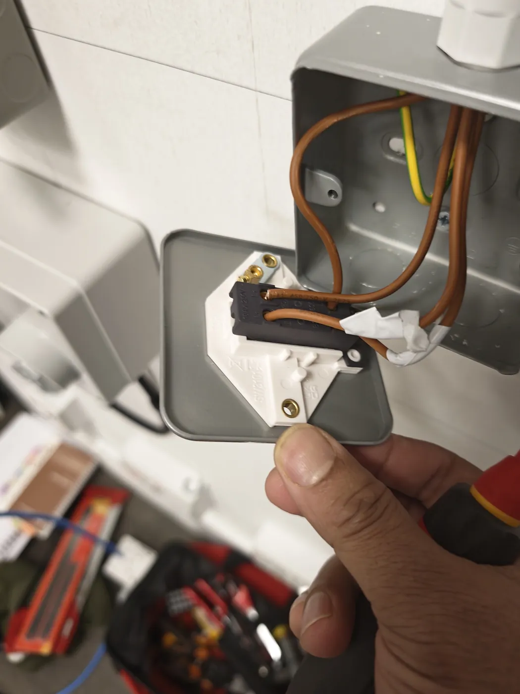 Electrician connecting wiring in a metal socket back box