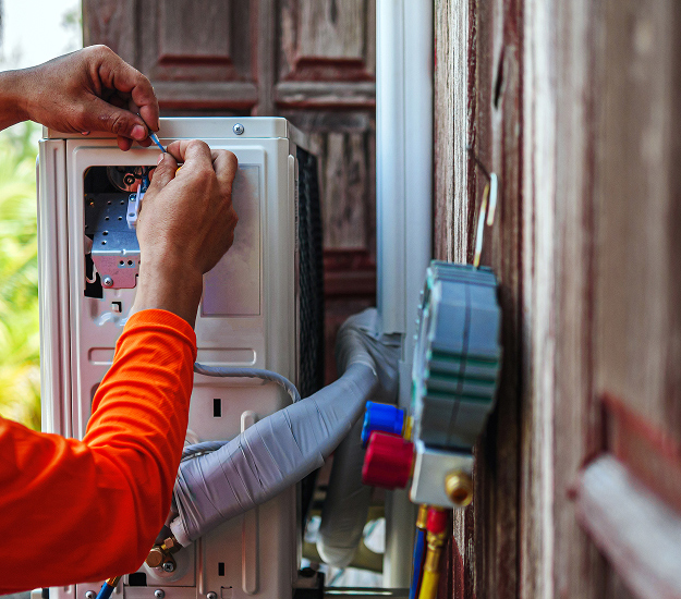 Electrician testing a wall-mounted electrical outlet