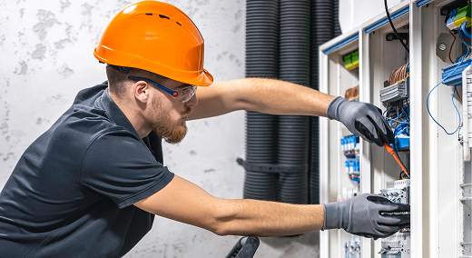 Electrician installing wiring for a new appliance at a wall unit